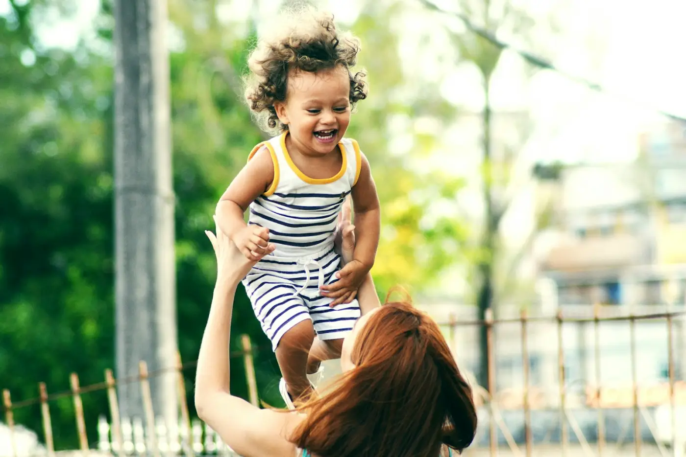 Madre jugando con su hijo pequeño al aire libre