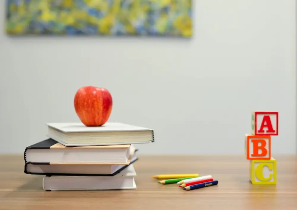 Manzana sobre libros y cubos de letras